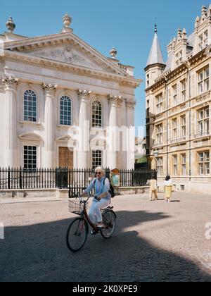 Sommertouristen, die zu Fuß und mit dem Fahrrad unterwegs waren, kamen am Senatshaus A 1720s der University of Cambridge in Cambridge Cambridgeshire England vorbei Stockfoto