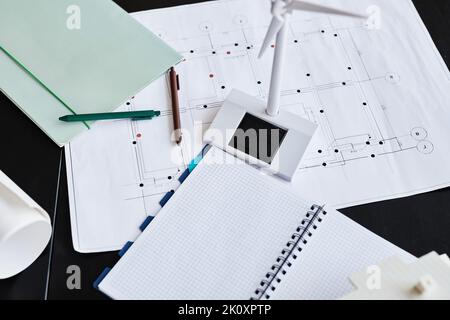Hochwinkelansicht des Architekturentwürfen und Windmühlenmockup auf dem Tisch des Architekten Stockfoto