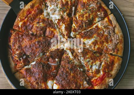 Leckere hausgemachte Thunfisch-Pizza. Nahaufnahme der hausgemachten traditionellen Pizza Stockfoto