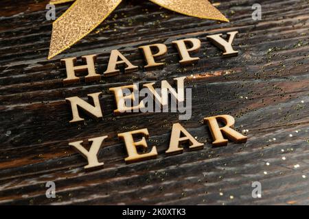 Frohes neues Jahr Holztext auf Holzhintergrund. Festliche Grußkarte. Stockfoto