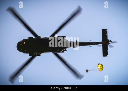 Johnston, Iowa, USA. 7. September 2022. Eine US-Army National Guard UH-60 Black Hawk Crew legt während einer Lufttropfen- und Schleuderbelastung im Rahmen eines U.S. Pathfinder Course am Septembertemberember im Camp Dodge in Johnston, Iowa, eine Schachtel mit verzehrfertigen Mahlzeiten ab. 8, 2022. Fast 30 Soldaten absolvierten den Kurs, der von einem mobilen Trainingsteam im Warrior Training Center der Army National Guard in Fort Benning, Georgia, durchgeführt wurde. Jeder Soldat wurde mit einem MRE-Paket beauftragt und mit der Koordination eines Luftabfalls an einem bestimmten Ort beauftragt. Army Pathfinders sind geschult, um Navigation A zu liefern Stockfoto