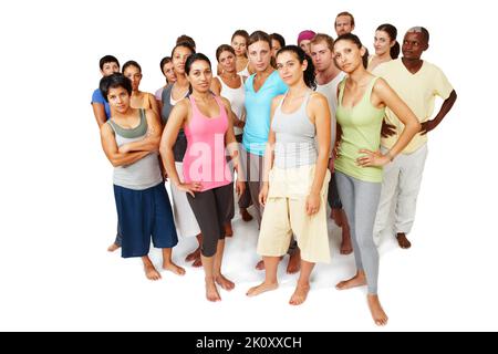 Sie haben sich der Fitness verschrieben. Ein ernsthafter und fokussierter Yoga-Kurs, der auf weißem Hintergrund zusammensteht. Stockfoto