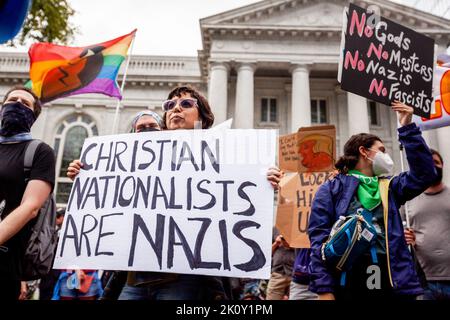 Washington, DC, USA. 26.. Juli 2022. Ein Anti-Trump-Protestler zeigt ein Plakat, auf dem christliche Nationalisten Faschisten aufgerufen werden, während er auf einer ersten amerikanischen Konferenz gegen Trumps Rede demonstriert. Christliche Nationalisten glauben, dass die Regierung handeln sollte, um das zu bewahren, was sie als die Identität der Vereinigten Staaten als ''christliche Nation'' bezeichnen.Dies ist der erste öffentliche Auftritt für Trump in Washington seit Bidens Amtsantritt. Anti-Trump-Demonstranten und Pro-Trump-Anhänger demonstrierten vor dem Marriott Marquis in Washington mit amerikanischen Flaggen, Plakaten und Spruchbändern, die meisten waren Mitglied Stockfoto