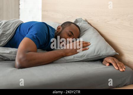 Schwarzer Mann Schläft Friedlich Im Bett Im Modernen Schlafzimmer Liegen Stockfoto