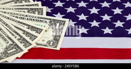US-Dollar-Scheine auf einer Flagge. Banner für Inflation, Finanzen oder Geldeinsparungen. Stockfoto