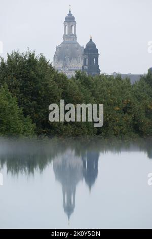Dresden, Deutschland. 14. September 2022. Die Kulisse der Dresdner Altstadt mit der Frauenkirche (l) und dem Ständehaus spiegelt sich in einer mit Regenwasser bedeckten Scheibe wider. Quelle: Sebastian Kahnert/dpa/Alamy Live News Stockfoto