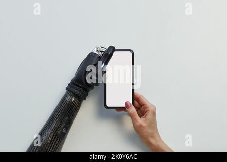 High-Angle-Ansicht von Mädchen mit prothetischen Arm mit Mobiltelefon auf weißem Hintergrund Stockfoto