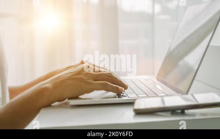 Nahaufnahme von Männerhänden mit einem Laptop im Heimbüro. Konzept der Web-Suche, Browsing Informationen. Soft-Fokus Stockfoto