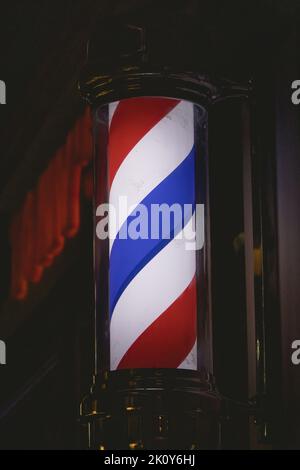 Eine vertikale Nahaufnahme des roten, blauen und weißen Barbierstange Stockfoto