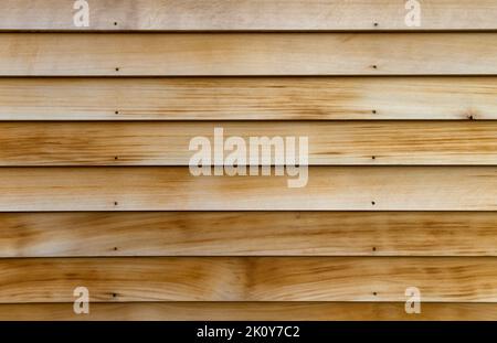 Horizontale Reihen aus Zedernholz als Außenwand im frühen Morgenlicht. Stockfoto