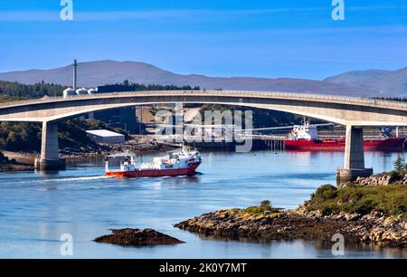 KYLE VON LOCHALSH SCHOTTLAND IM SPÄTSOMMER EIN ORANGEFARBENES MOWI-SCHIFF UNTER DER SKYE-BRÜCKE Stockfoto