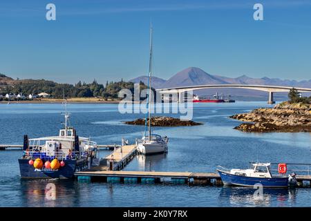 KYLE VON LOCHALSH SCHOTTLAND SPÄTSOMMER VERTÄUTE BOOTE, DIE TEIL DER SKYE-BRÜCKE MIT CUILLINS IN DER FERNE WAREN Stockfoto