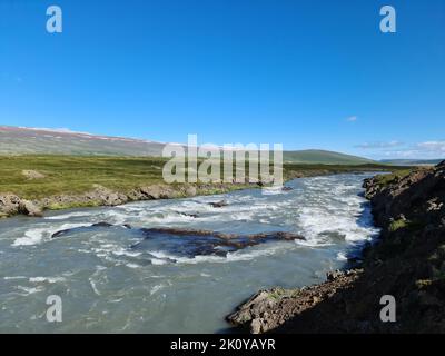 Fantastische Landschaft mit fließenden Flüssen und Bächen mit Felsen und Gras in Island Stockfoto