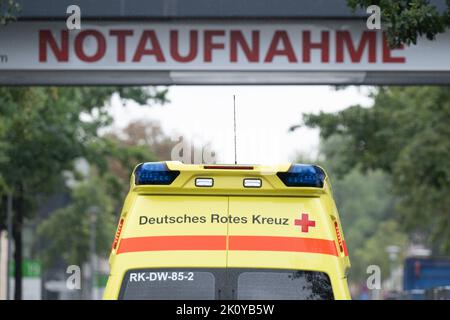 Dresden, Deutschland. 14. September 2022. Ein Krankenwagen fährt auf dem Gelände des Dresdner Universitätsklinikums vor einem Schild mit der Aufschrift „Notaufnahme“. Drastisch steigende Energiekosten und Inflation setzen die Krankenhäuser in Sachsen unter wirtschaftlichen Druck. Quelle: Sebastian Kahnert/dpa/Alamy Live News Stockfoto