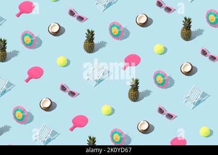 Sommermuster mit bunten Objekten - Ananas, Kokosnuss, Sonnenbrille, Cocktailschirm, Tennisball und Schläger und Strandstuhl auf blauem Hintergrund. Stockfoto