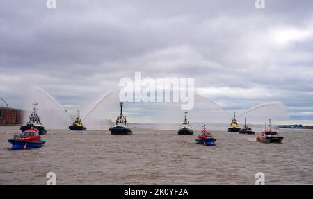 Flussschlepper führen Fleur De Lis vor, als sich Schiffe auf dem River Mersey in Liverpool vor den Three Graces (Liver Building, Cunard Building und Port of Liverpool Building) für eine maritime Hommage an Königin Elizabeth II. Versammeln. Die vor ihrer Beerdigung am Montag in der Westminster Hall in London im Staat liegen wird. Bilddatum: Mittwoch, 14. September 2022. Stockfoto