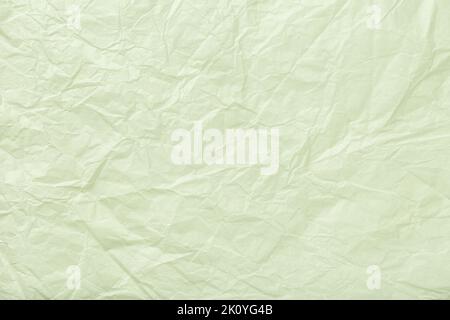 Textur aus zerknittertem pastellgrünem Geschenkpapier, Nahaufnahme. Olive abstrakter Hintergrund. Dekorativer Hintergrund. Stockfoto