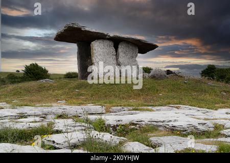 Der Poulnabrone Dolmen. Der Poulnabrone Dolmen liegt auf dem hohen Kalksteinplateau von Burren und ist eines der berühmtesten archäologischen Denkmäler Irlands. Stockfoto