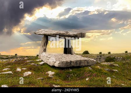 Der Poulnabrone Dolmen. Der Poulnabrone Dolmen liegt auf dem hohen Kalksteinplateau von Burren und ist eines der berühmtesten archäologischen Denkmäler Irlands. Stockfoto