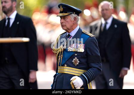 König Karl III. Geht hinter den Sarg von Königin Elizabeth II., der im Royal Standard mit der Krone des Kaiserlichen Staates auf der Oberseite drapiert ist, während er auf einer Pferdekutsche der Königstruppe Royal Horse Artillery getragen wird, während der feierlichen Prozession vom Buckingham Palace zur Westminster Hall, London, wo sie vor ihrer Beerdigung am Montag liegen wird. Bilddatum: Mittwoch, 14. September 2022. Stockfoto