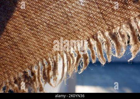 Eine Nahaufnahme von khaddar oder khadi, Baumwolltuch im Detail gegen Sonnenlicht. Khaddar ist eine Art von einfachem Baumwolltuch, das in Indien hergestellt wird. Stockfoto