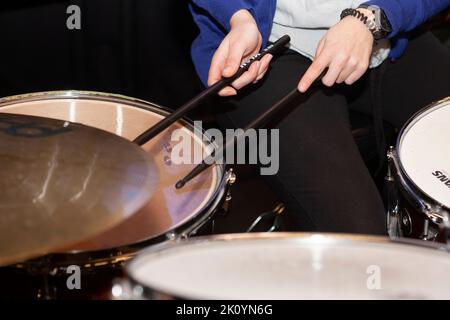 Nahaufnahme eines Musikerpaares mit Drumsticks, während man in einem Amateurorchester eine Snare-Trommel spielt Stockfoto