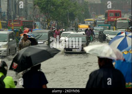 Dhaka. 14. September 2022. Menschen und Fahrzeuge werden am 14. September 2022 auf einer wasserbefahrenen Straße in Dhaka, Bangladesch, gesehen. Moderate bis schwere Regenfälle haben am Mittwoch Teile der bangladeschischen Hauptstadt Dhaka heimgesucht, tief liegende Gebiete invutiert und den Straßenverkehr gestört. Quelle: Xinhua/Alamy Live News Stockfoto