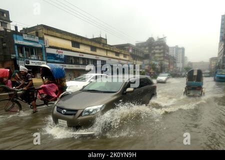 Dhaka. 14. September 2022. Autos werden am 14. September 2022 auf einer wasserbefahrenen Straße in Dhaka, Bangladesch, gesehen. Moderate bis schwere Regenfälle haben am Mittwoch Teile der bangladeschischen Hauptstadt Dhaka heimgesucht, tief liegende Gebiete invutiert und den Straßenverkehr gestört. Quelle: Xinhua/Alamy Live News Stockfoto