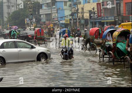 Dhaka. 14. September 2022. Fahrzeuge und Rikscha-Transporter werden am 14. September 2022 auf einer wasserbefahrenen Straße in Dhaka, Bangladesch, gesehen. Moderate bis schwere Regenfälle haben am Mittwoch Teile der bangladeschischen Hauptstadt Dhaka heimgesucht, tief liegende Gebiete invutiert und den Straßenverkehr gestört. Quelle: Xinhua/Alamy Live News Stockfoto