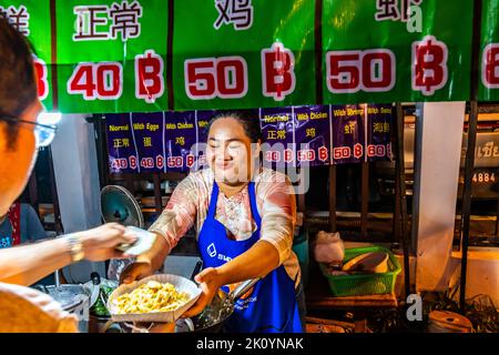 CHIANG MAI, THAILAND - 3.11.2019: Frauen bereiten auf dem Nachtmarkt in Chiang Mai Street Food zu. Berühmtes thailändisches Essen namens Pad Thai, bestellt von t Stockfoto