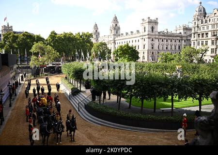 Der Sarg von Königin Elizabeth II., der im Royal Standard mit der darauf liegenden Kaiserkrone drapiert ist, wird auf einer Pferdekutsche der Königstruppe Royal Horse Artillery getragen und kommt in der Westminster Hall in London an, wo er vor ihrer Beerdigung am Montag in einem Zustand liegen wird. Bilddatum: Mittwoch, 14. September 2022. Stockfoto