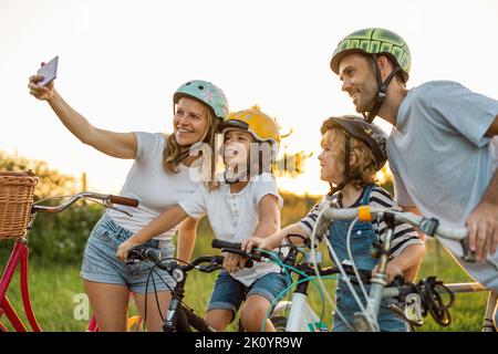 Glückliche Familie, die gemeinsam auf dem Land radelt Stockfoto