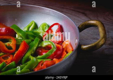 Eine grüne und rote Paprika in einer Pfanne braten Stockfoto