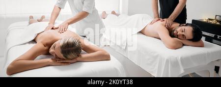 Paarmassage im Spa Resort. Wunderschönes Paar, das eine Rückenmassage mit Masseuren bekommt, romantisches Wochenende und Entspannung Stockfoto
