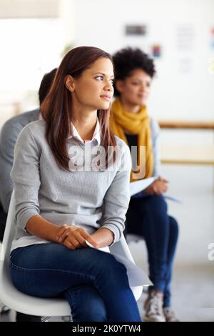 Tagträumen während des Treffens. Drei Mitarbeiter sitzen während eines Büromeeting. Stockfoto
