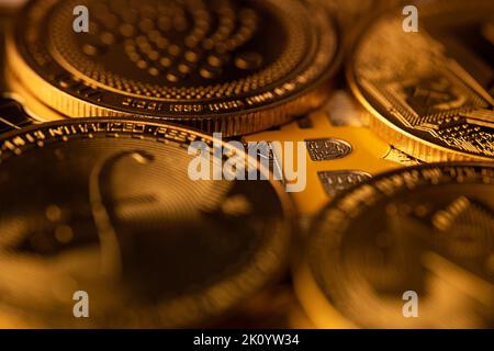 Draufsicht Makro-Nahaufnahme der Krypto-Bitcoin-Silbermünze auf einem Stapel anderer goldener Kryptowährungsmünzen Stockfoto
