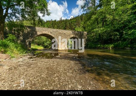 Rabstejn nad Strelou, Tschechische Republik - Juni 12 2022: Blick auf die historische Sandsteinbrücke über den Fluss Strela aus dem 14.. Jahrhundert, eine Sekunde Stockfoto