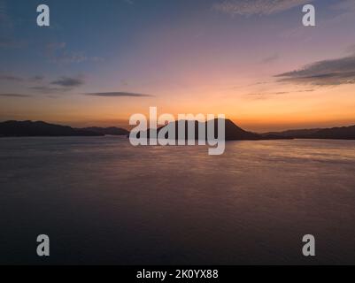 Wunderschöne Vordämmerung Farbe in Himmel und Meer rund um kleine Küsteninsel Stockfoto