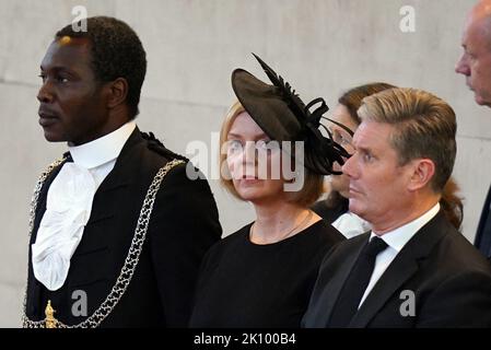 Premierminister Liz Truss (Mitte) und Sir Keir Starmer (rechts) beobachten, wie die Trägerin den Sarg von Königin Elizabeth II. In die Westminster Hall, London, trägt, wo er vor ihrer Beerdigung am Montag in einem Zustand liegen wird. Bilddatum: Mittwoch, 14. September 2022. Stockfoto