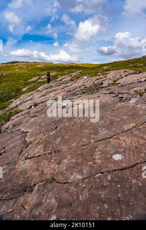 Frau, die am Pass der Rinder läuft, applecross, schottland, großbritannien Stockfoto