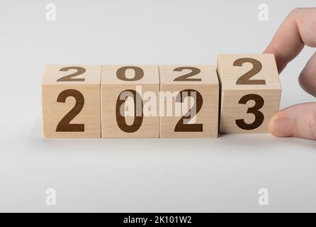 Holzwürfel-Flipping, Wechsel von 2022 auf 2023. Glückliches neues Jahr-Konzept, Würfelblock-Wechsel von 2022 auf 2023. Würfel mit Flipblock 2022 auf 2023. B Stockfoto