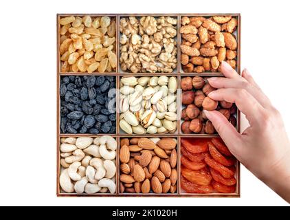 Hand mit verschiedenen Nüssen und Sammlung von Trockenfrüchten. Verschiedene Nüsse Mandeln, Pistazien, Cashews, Walnuss. Organische Mischnüsse Hintergrund. Gesundes Essen, wir Stockfoto