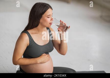 Körperhydratisierung. Schöne Junge Schwanger Frau Trinkwasser Aus Glas Zu Hause Stockfoto