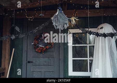 Gruselig fliegende hängende Spielzeug Geist.Dekorieren der Veranda auf der Straße für halloween Holiday.bat Girlande, Kranz aus alten leaves.DIY Haus, Straße dekorieren Stockfoto