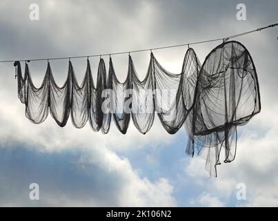 Ein Fischernetz (Reifennetz oder Fyke), das an einem Kabel hängt. Diese Netze werden in Elburg, Niederlande, zur Verschönerung der Hauptstraße eingesetzt Stockfoto