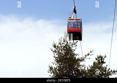 Rote Gondel mit Touristenfahrten auf der Seilbahn Stockfoto