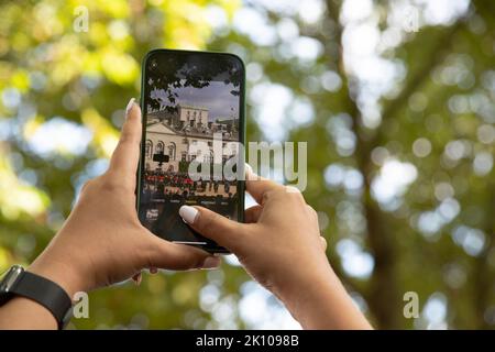 London, England. 14.. September 2022. Eine Trauerin zeichnet die letzte Reise der Königin auf ihrem Mobiltelefon auf. Der Sarg der Königin wurde in die Westminster Hall gebracht, wo sie bis zum Tag ihrer Beerdigung im Zustand liegen wird. Quelle: Kiki Streitberger / Alamy Live News Stockfoto