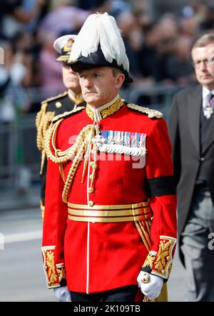 Der Hausmeister im Buckingham Palace, der Vizeadmiral Sir Anthony Johnstone-Burt, der den Sarg von Königin Elizabeth II., drapiert im Royal Standard, mit der Krone des Kaiserlichen Staates, auf den Kopf gestellt, Während der feierlichen Prozession vom Buckingham Palace zur Westminster Hall, London, wird sie auf einer Pferdekutsche der Königstruppe Royal Horse Artillery entlang Whitehall getragen, wo sie vor ihrer Beerdigung am Montag in einem Zustand liegen wird. Bilddatum: Mittwoch, 14. September 2022. Stockfoto