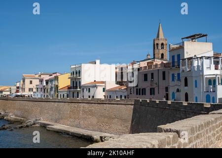 Alte Stadtgebäude, einschließlich des Turms der Kathedrale von Alghero, entlang der Stadtmauer in Alghero, Sardinien, Italien Stockfoto