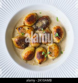 Knusprige Gnocchi gefüllt mit Pilzen (Boletus edulis) mit Trüffelsauce Stockfoto